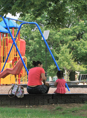 Young adult and child near play structure.
