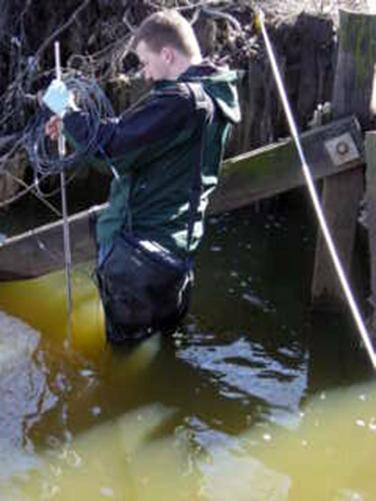 Photo: S. Yergeau sampling Kearny Marsh water after a storm event.